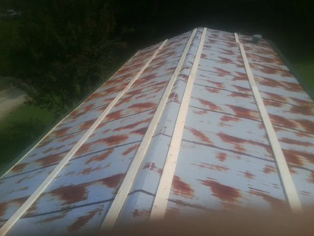 Rusted metal roof panels with new wood purlins before replacement — Storm Damage Roof Repair in Perkinston by Roofing Brothers