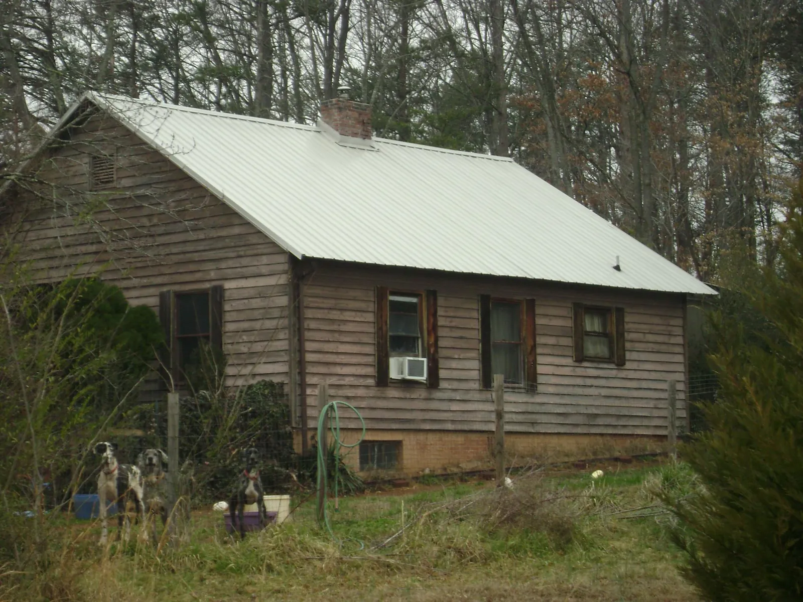 White metal roof on an old wood sided farmhouse, from a Metal Roof Installation job in Perkinston